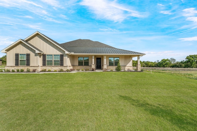 view of front facade with board and batten siding, stone siding, and a front yard