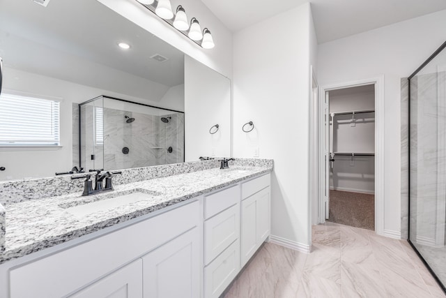 full bathroom with a spacious closet, marble finish floor, visible vents, a sink, and a stall shower