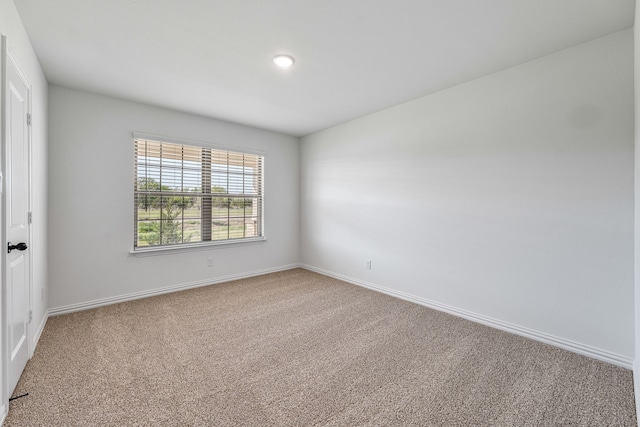 carpeted empty room with baseboards
