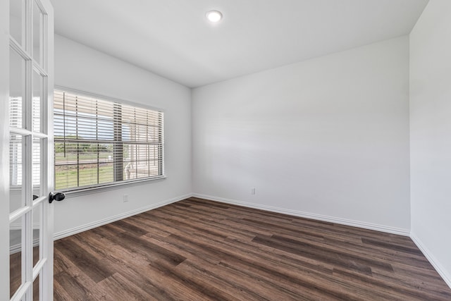 empty room with baseboards, dark wood-type flooring, and recessed lighting