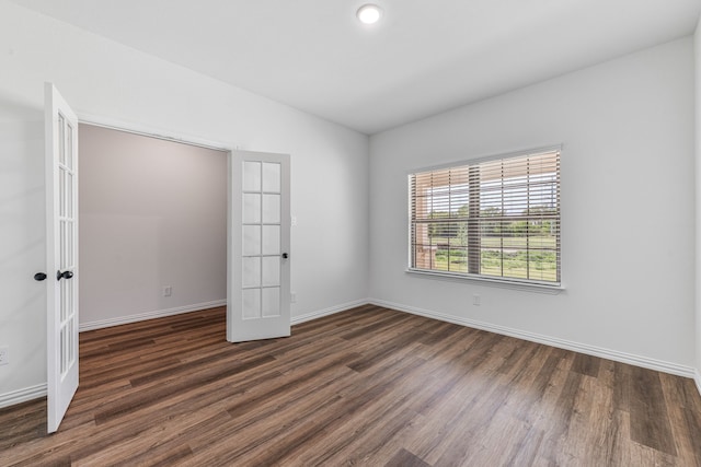 unfurnished bedroom featuring baseboards, dark wood-style flooring, and french doors