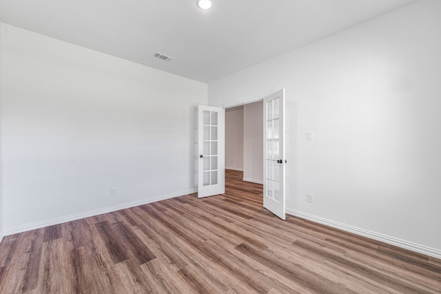 unfurnished room featuring wood finished floors, french doors, baseboards, visible vents, and recessed lighting