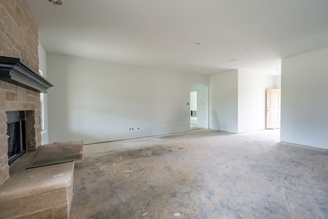 unfurnished living room with a stone fireplace