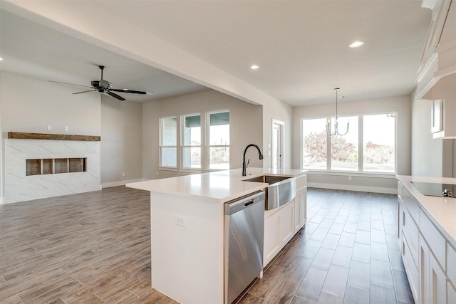 kitchen featuring white cabinetry, dishwasher, sink, hanging light fixtures, and an island with sink