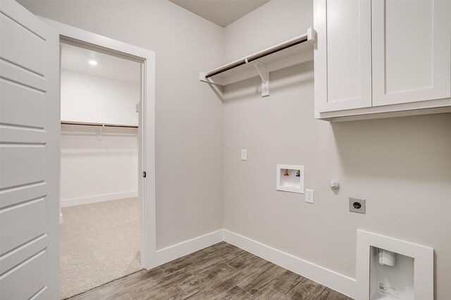 washroom featuring cabinets, washer hookup, gas dryer hookup, electric dryer hookup, and hardwood / wood-style flooring