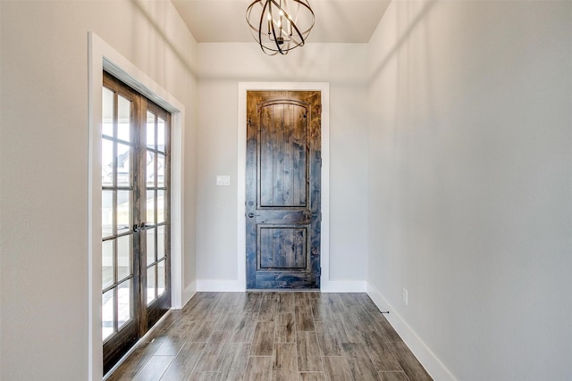 foyer with french doors, a notable chandelier, and hardwood / wood-style flooring