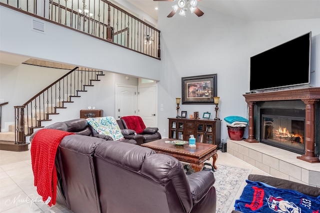 tiled living room with high vaulted ceiling and a tiled fireplace