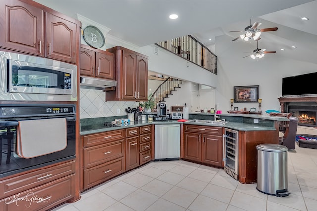 kitchen featuring light tile patterned flooring, sink, black appliances, kitchen peninsula, and beverage cooler