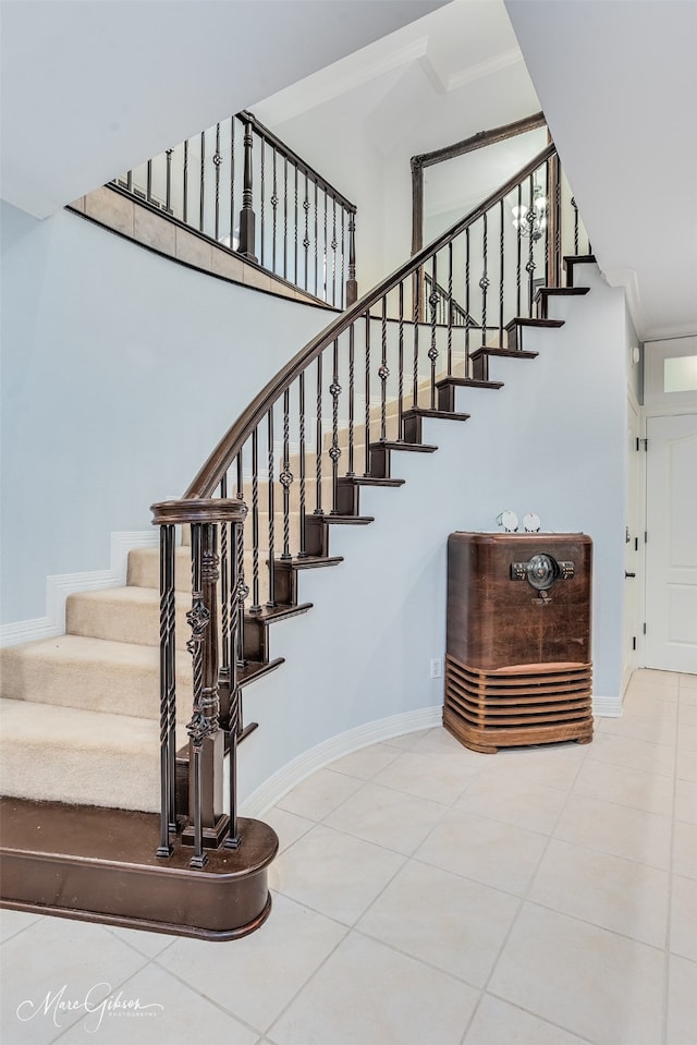 stairs featuring ornamental molding and tile patterned flooring