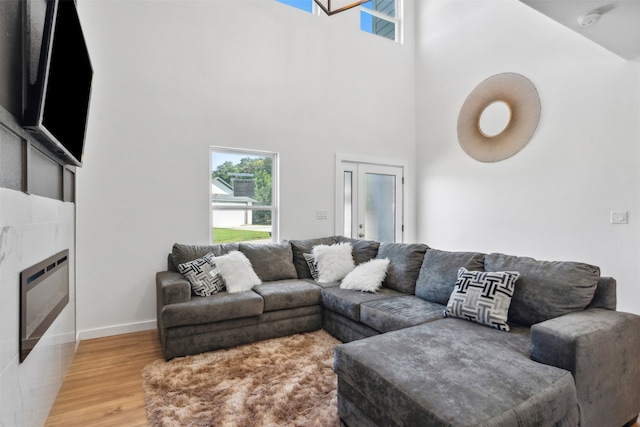 living room with a towering ceiling and wood-type flooring