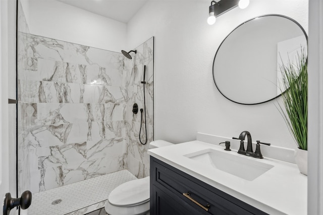 bathroom with toilet, vanity, and a tile shower