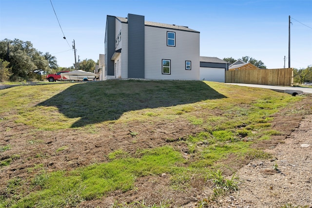 back of house featuring a garage and a yard