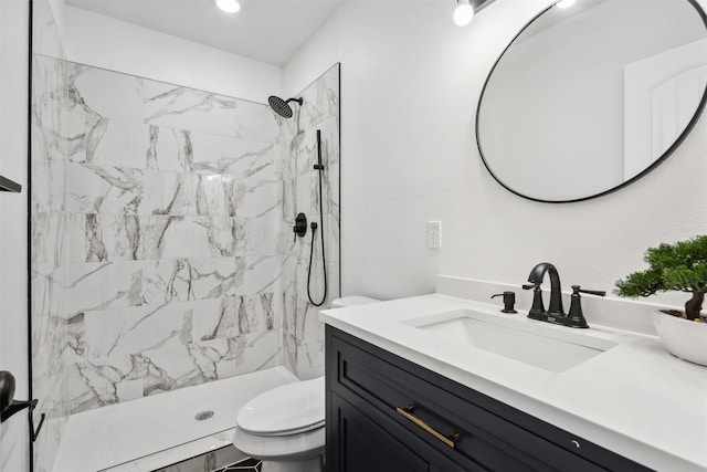 bathroom featuring vanity, toilet, and a tile shower