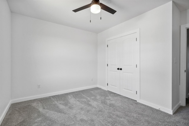 unfurnished bedroom with ceiling fan, carpet flooring, and a closet