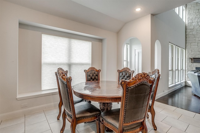 dining room featuring light tile patterned flooring and vaulted ceiling