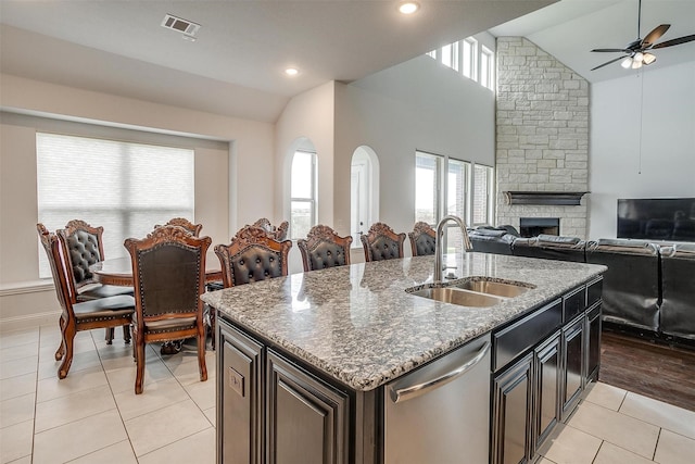 kitchen with a center island with sink, a sink, lofted ceiling, and dishwasher