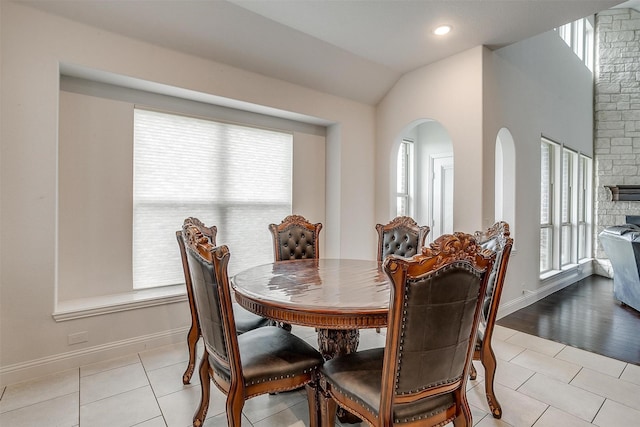 dining space featuring light tile patterned floors, plenty of natural light, and vaulted ceiling