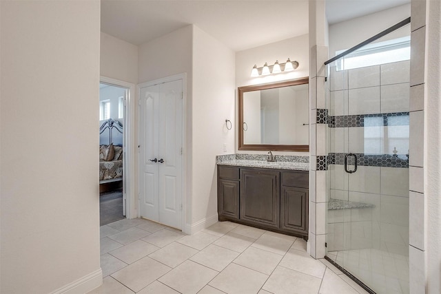 bathroom featuring a shower stall, baseboards, tile patterned flooring, and vanity