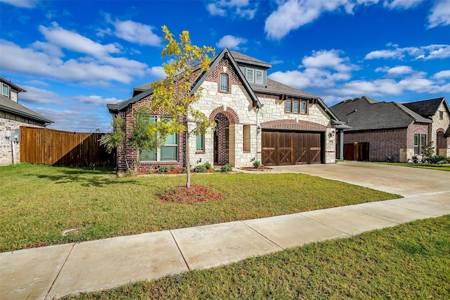 view of front of home with stone siding, fence, concrete driveway, and a front yard