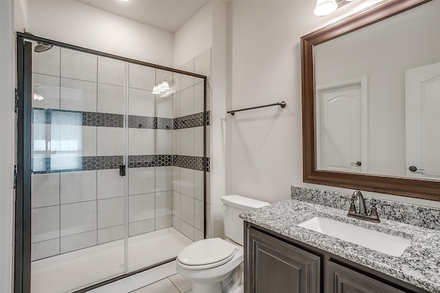 bathroom with tile patterned flooring, vanity, toilet, and an enclosed shower