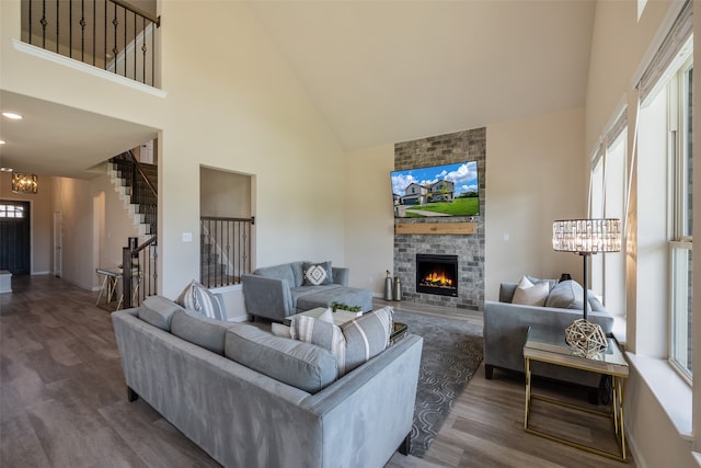 living room featuring a wealth of natural light, hardwood / wood-style flooring, a fireplace, and high vaulted ceiling