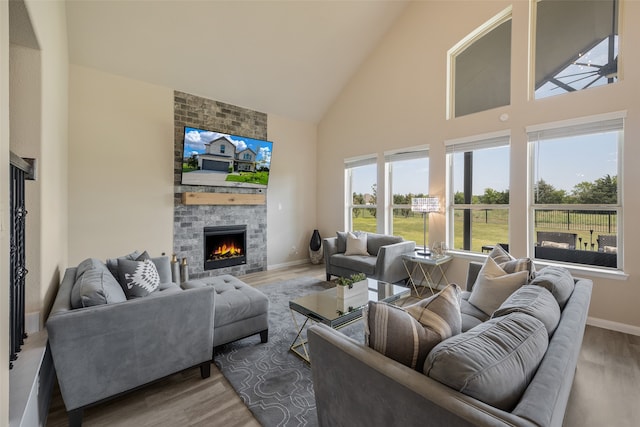 living room with high vaulted ceiling, wood-type flooring, and a brick fireplace