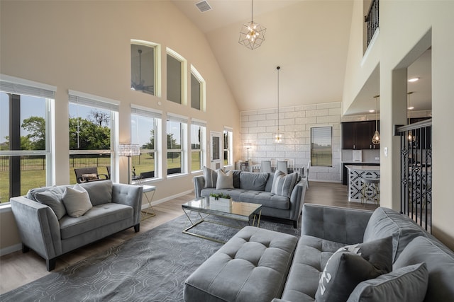 living room featuring dark hardwood / wood-style floors, high vaulted ceiling, and a notable chandelier