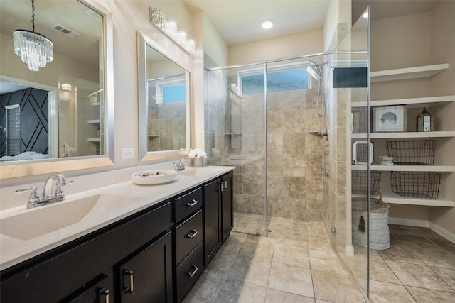 bathroom featuring an inviting chandelier, vanity, tile patterned floors, and a shower with shower door