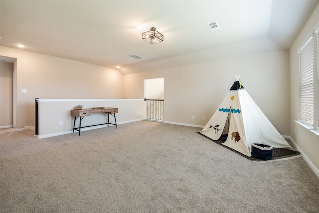 recreation room featuring light colored carpet and lofted ceiling