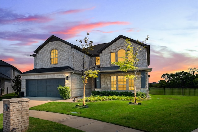 french provincial home featuring a garage and a yard