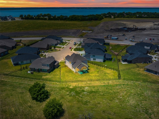 aerial view at dusk featuring a water view