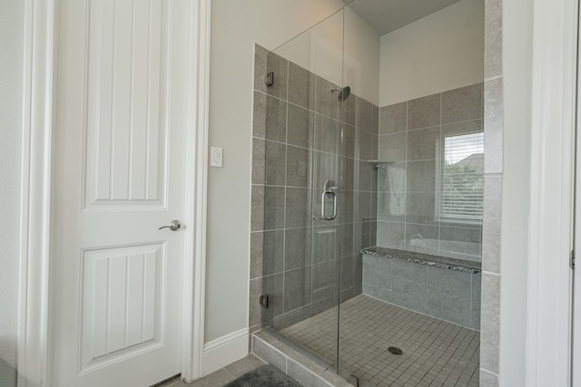 bathroom with tile patterned floors and a shower with door