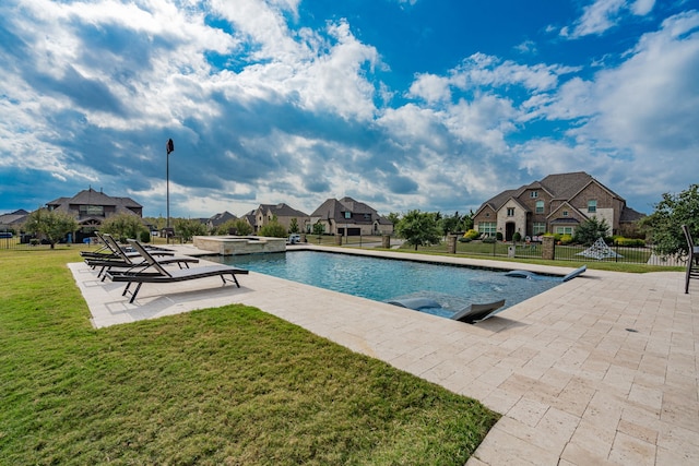 view of pool featuring an in ground hot tub, a patio, and a lawn