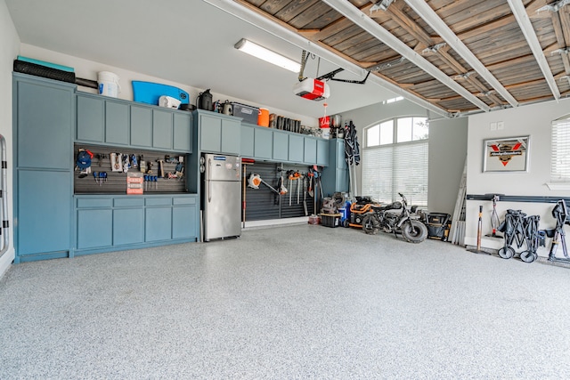 garage with stainless steel fridge and a garage door opener