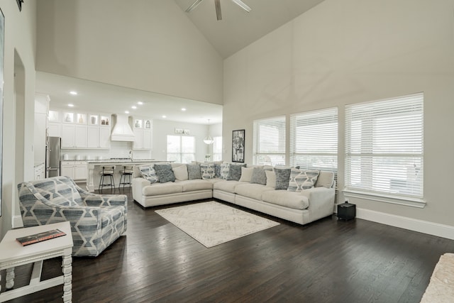 living room featuring dark hardwood / wood-style floors, ceiling fan, and high vaulted ceiling