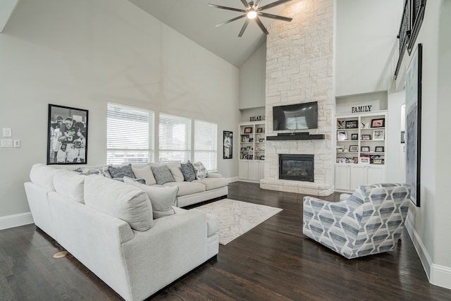 living room featuring high vaulted ceiling, built in shelves, ceiling fan, a fireplace, and dark hardwood / wood-style flooring