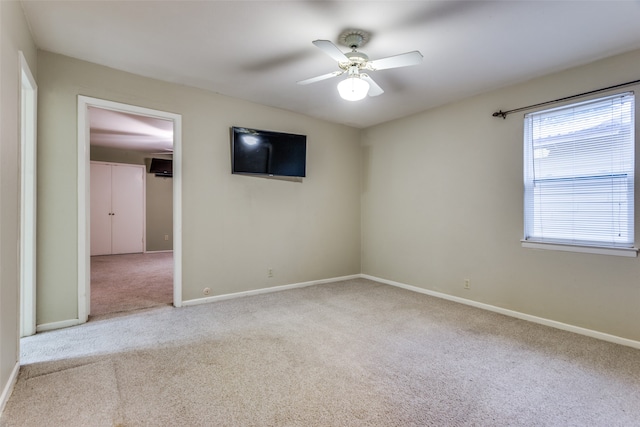 carpeted spare room featuring ceiling fan