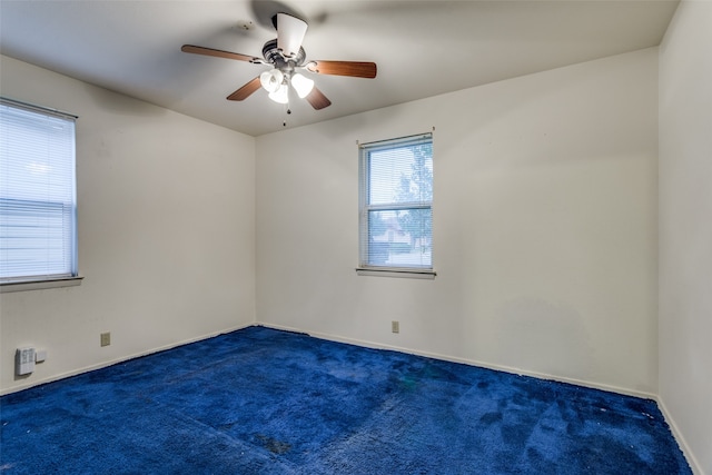 unfurnished room featuring ceiling fan and dark colored carpet