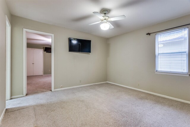 unfurnished room with baseboards, ceiling fan, and carpet