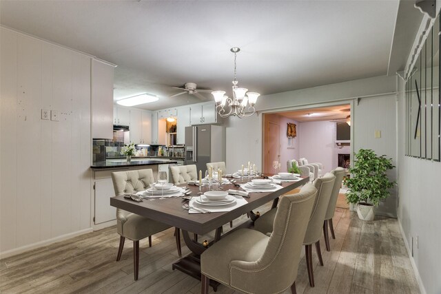 dining space with a chandelier, light wood-type flooring, and baseboards