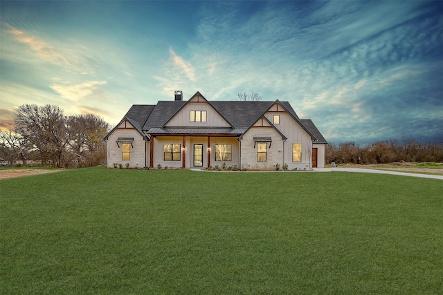 modern farmhouse with a front yard, a standing seam roof, a chimney, board and batten siding, and metal roof