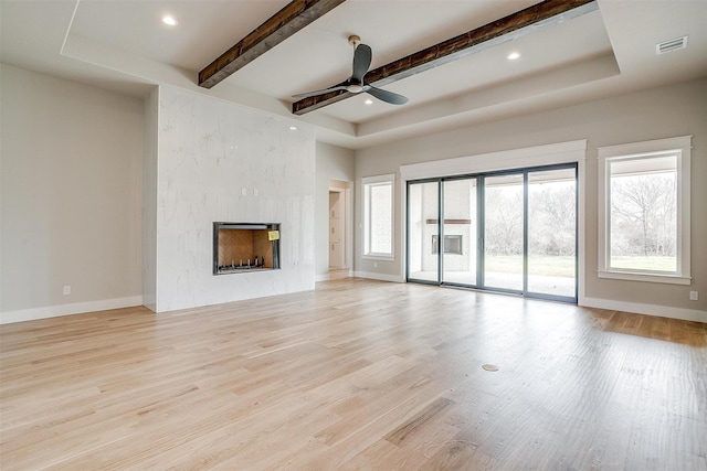 unfurnished living room featuring a fireplace, baseboards, and wood finished floors