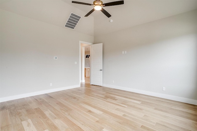 spare room with visible vents, baseboards, high vaulted ceiling, light wood-style flooring, and ceiling fan