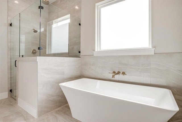 full bathroom with a soaking tub, tile walls, and a stall shower