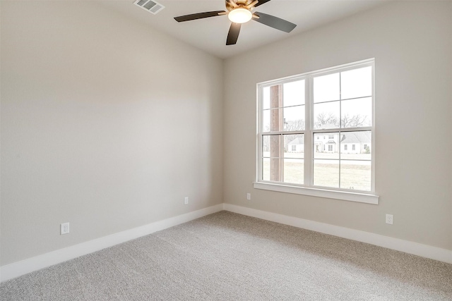 spare room featuring a ceiling fan, baseboards, visible vents, and carpet floors