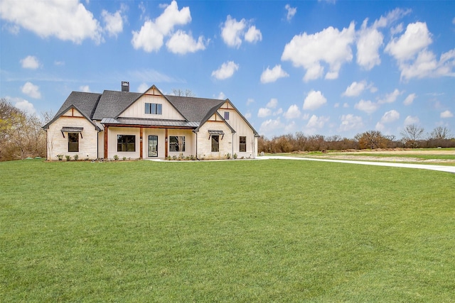 modern farmhouse featuring board and batten siding, a shingled roof, a front lawn, a chimney, and a standing seam roof