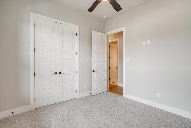 unfurnished bedroom with carpet flooring, baseboards, a closet, and ceiling fan