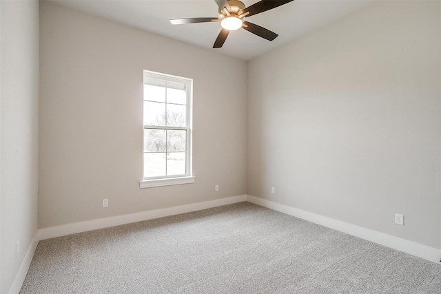 carpeted empty room featuring baseboards and ceiling fan