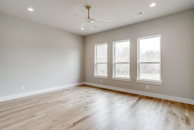 spare room with a wealth of natural light, light wood-type flooring, and baseboards