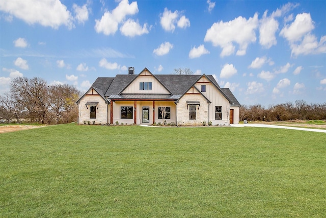 modern farmhouse with board and batten siding, a front yard, a chimney, metal roof, and a standing seam roof